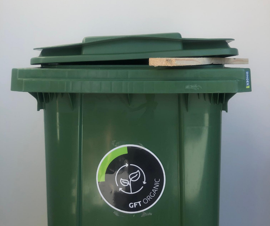 Groene afvalcontainer met open deksel