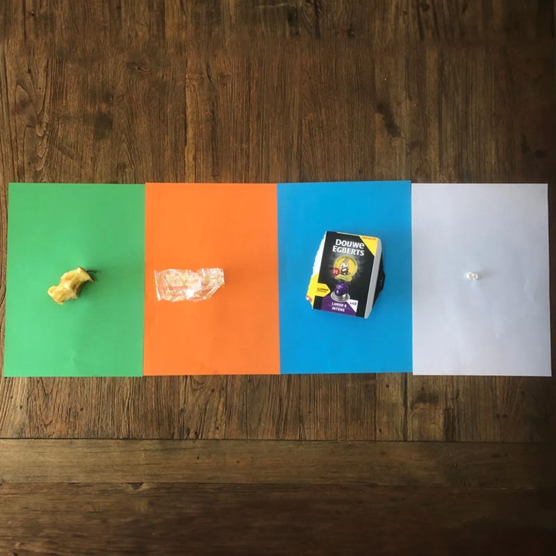 Tafel met 4 gekleurde velletjes papier voor afvalkleurenspel