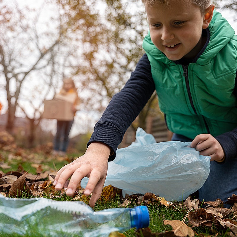Kind verzamelt afval buiten - zwerfafval
