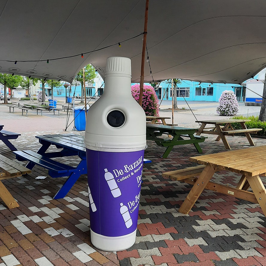 Witte gekleurde inzamelbak plastic statiegeld flesjes terras 