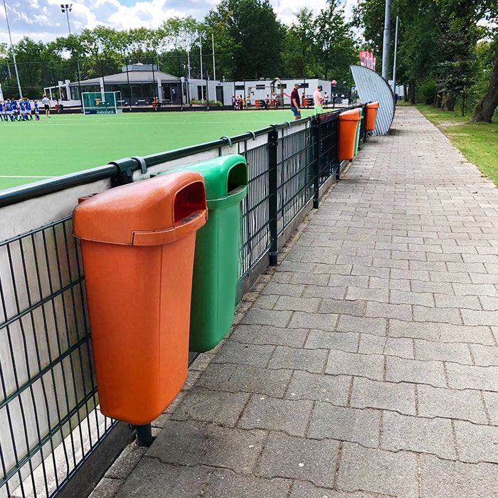 Buitenafvalbakken langs de lijn bij een voetbalclub